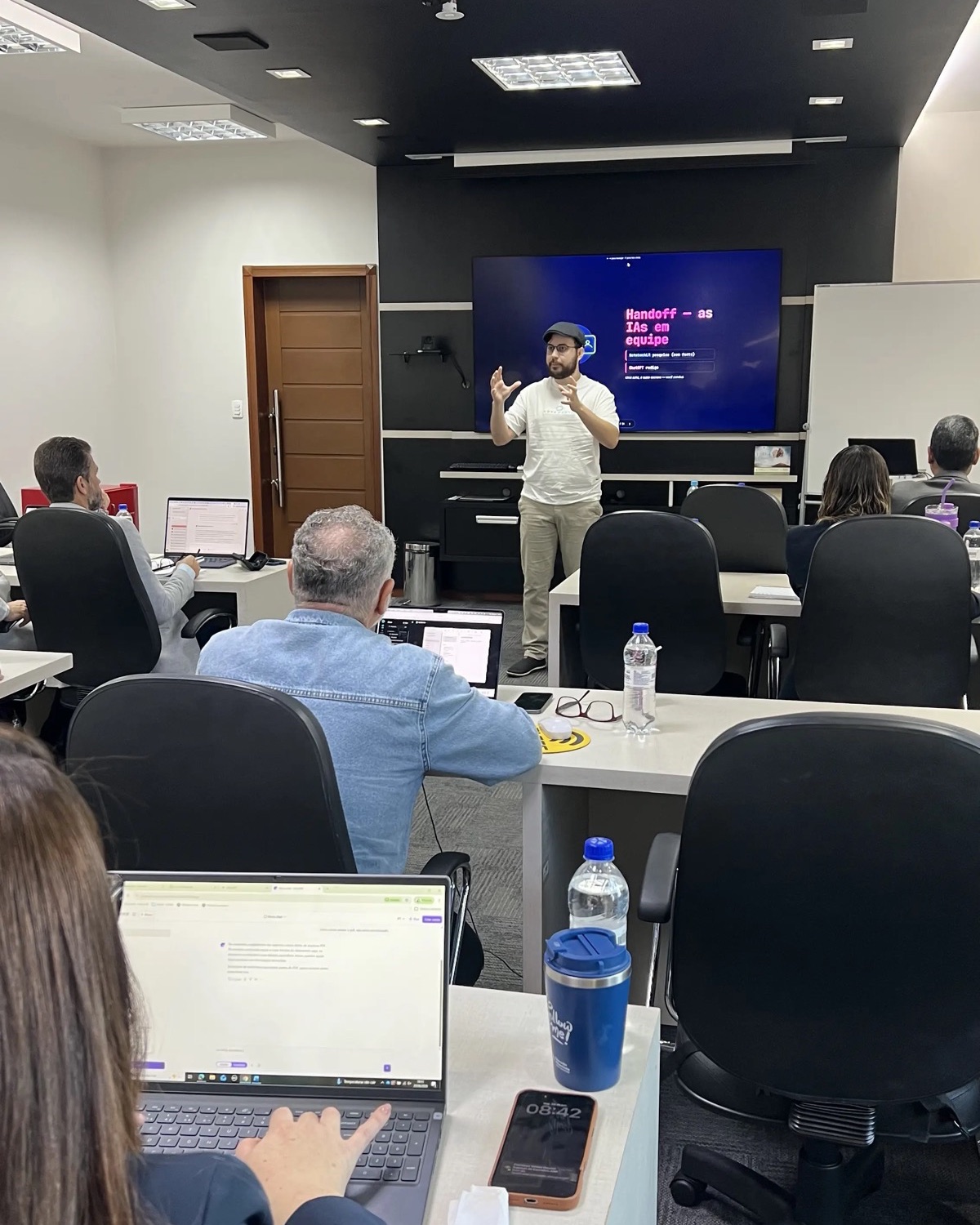 Sala de treinamento da Navit com participantes e apresentação projetada